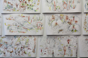 A collage of expressive, abstract sketches featuring human figures in various poses with colorful, dynamic lines and marks on white paper.