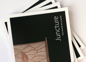 A pile of exhibition catalogues titled Juncture featuring First Nations art on the cover.