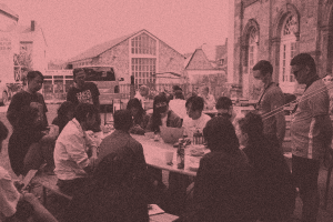 A group of people sitting around a bench working